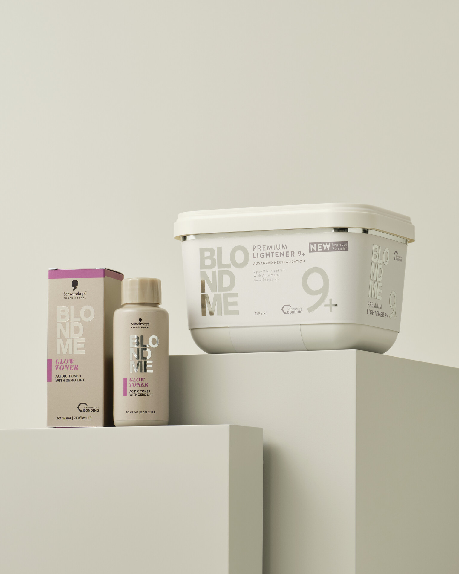 Schwarzkopf Professional BlondMe Glow Toner und BlondMe Premium Lightener 9+ auf hellem Podest vor neutralem Hintergrund.